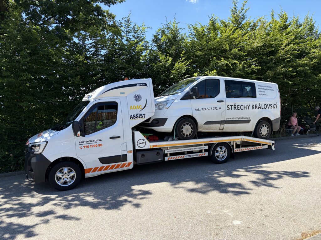 Automobil s otevřenou kapotou a párou z motorového prostoru po přehřátí motoru.